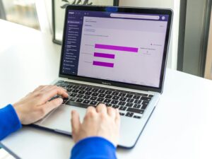 Person working on a laptop with business analytics displayed on the screen.