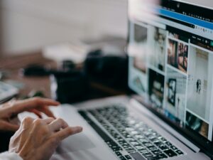 A person working on a laptop browsing visual content in an indoor setting, capturing digital creativity and remote work.