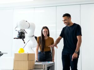 Two engineers collaborating on testing a futuristic robotic prototype in a modern indoor lab.