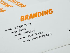 Close-up of a paper with branding, identity, design, strategy, and marketing concepts in orange and black.