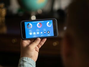 A person holds a smartphone displaying business strategy stages chart indoors.